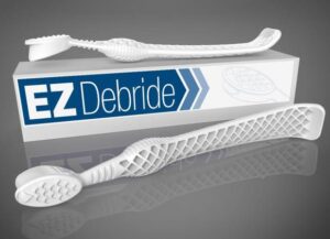 EZ Debride wound-care tools resting on their box, white textured surgical probes on a gray background.